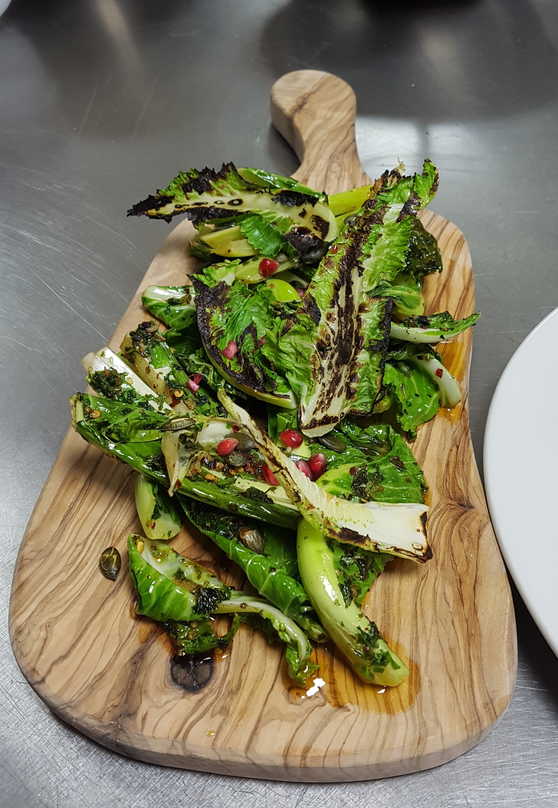 Fried and Charred Cauliflower Leaves. With Pomegranate Seeds and Toasted Pumpkin Seeds.