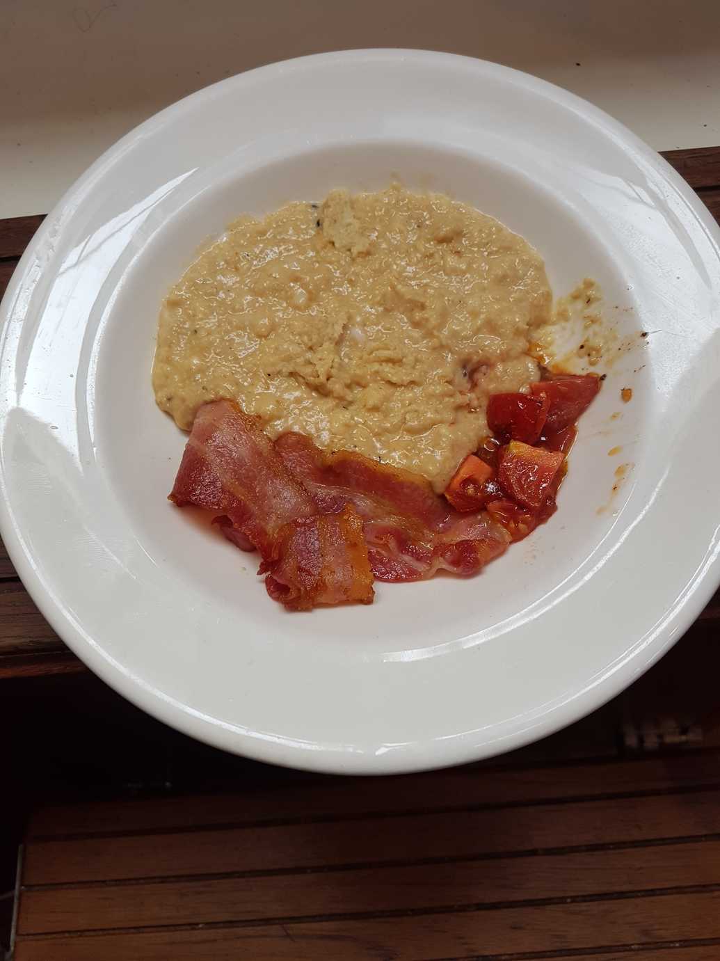 Scrambled Porridge Eggs. With bacon and fried tomatoes.