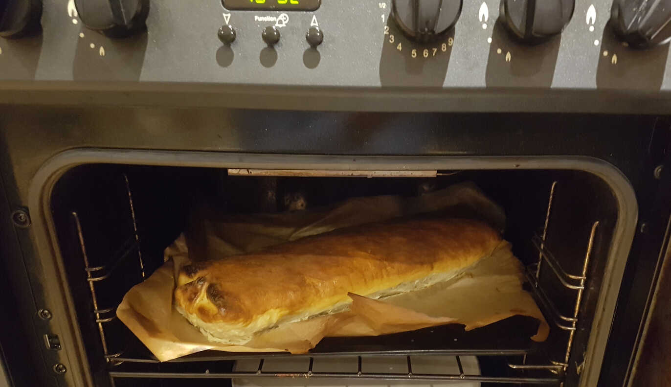 A large cheesy log in a small oven