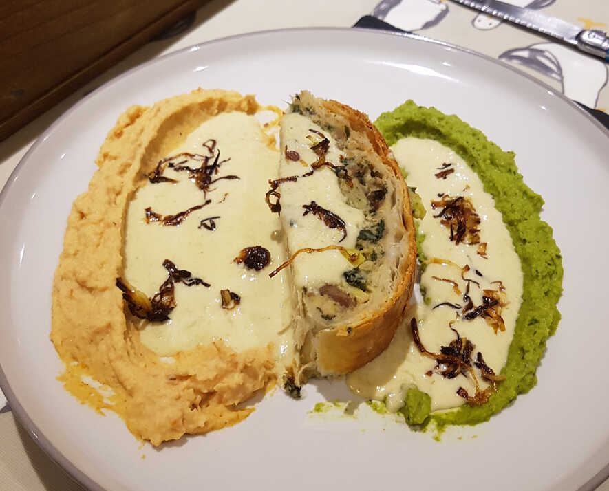 One presentation of Chestnut and Goronzola en Croute, served with Mint Purée, Celeriac and Sun-Dried Tomato Purée, Leek Sauce, and Caramelised Leek Spiders.